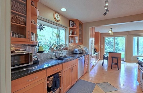Northwest Calgary House | Almost 1/2 an acre on the Bow River, huge fenced yard, hot tub, firepit, games!