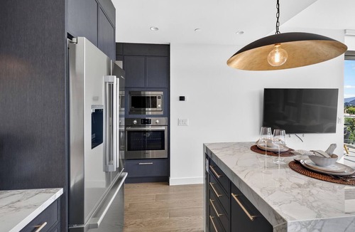South Pandosy Condo | Luxury 2BR waterfront condo at AQUA Kelowna with a king suite, queen bedroom, private BBQ patio, high end designer interiors, quartz counters, custom navy cabinetry, premium appliances & steps from Okanagan Lake.