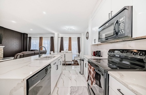 Bridlewood House | Luxury 4 Bedroom detached, vacation home in SW Calgary. King-size bed.