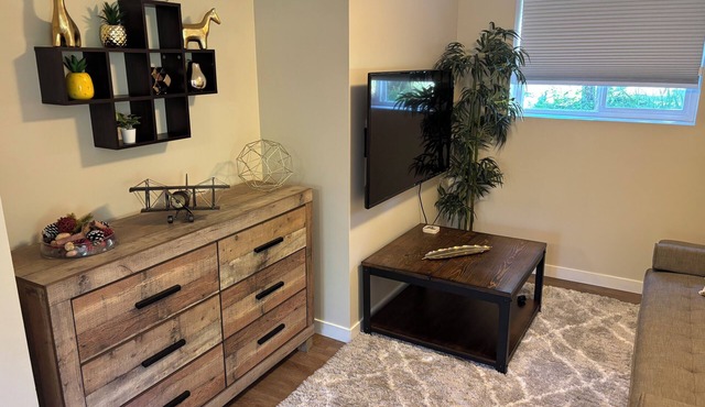 A bright and cozy 1-bedroom basement suite is nestled in a lush garden setting